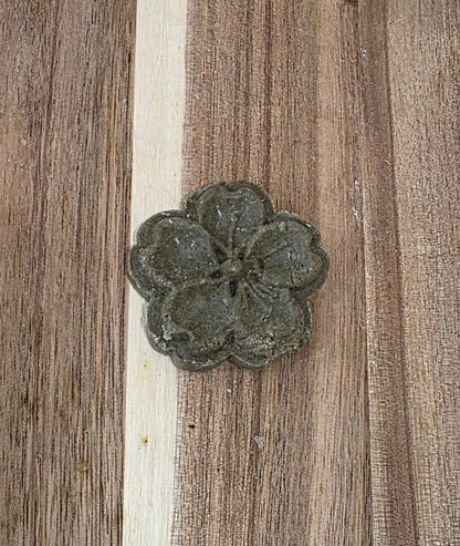 Decorative metal flower on a wooden surface