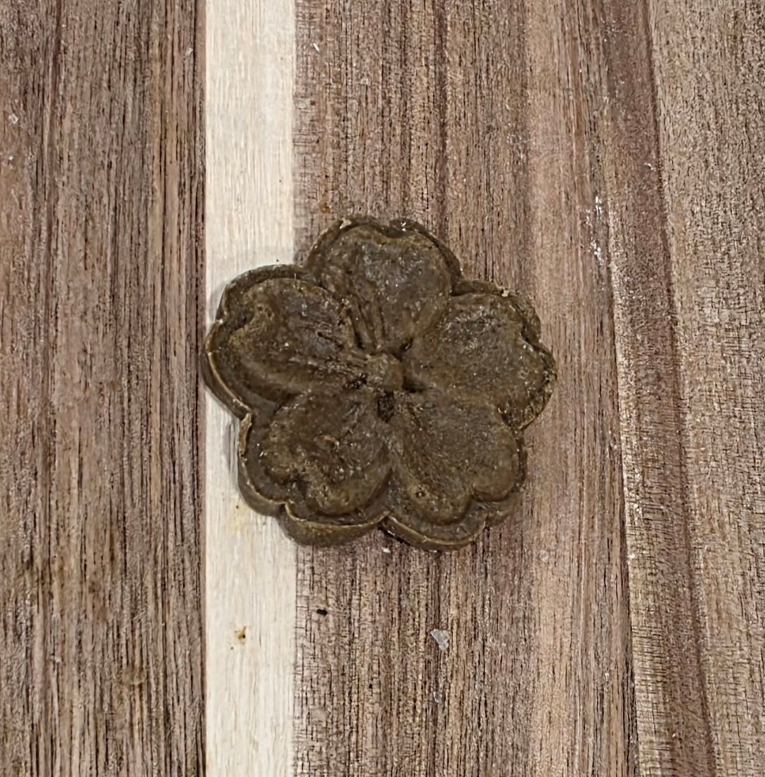 Decorative metal flower on a wooden surface