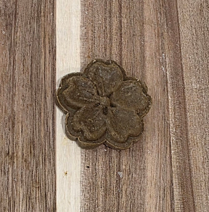 Decorative metal flower on a wooden surface