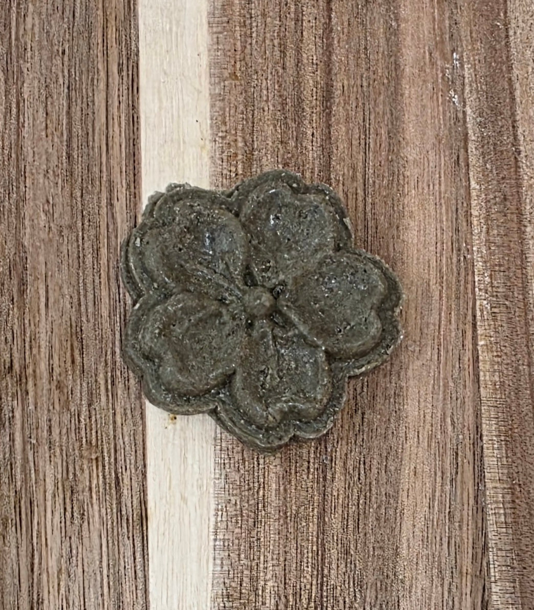 Decorative metal flower on a wooden surface